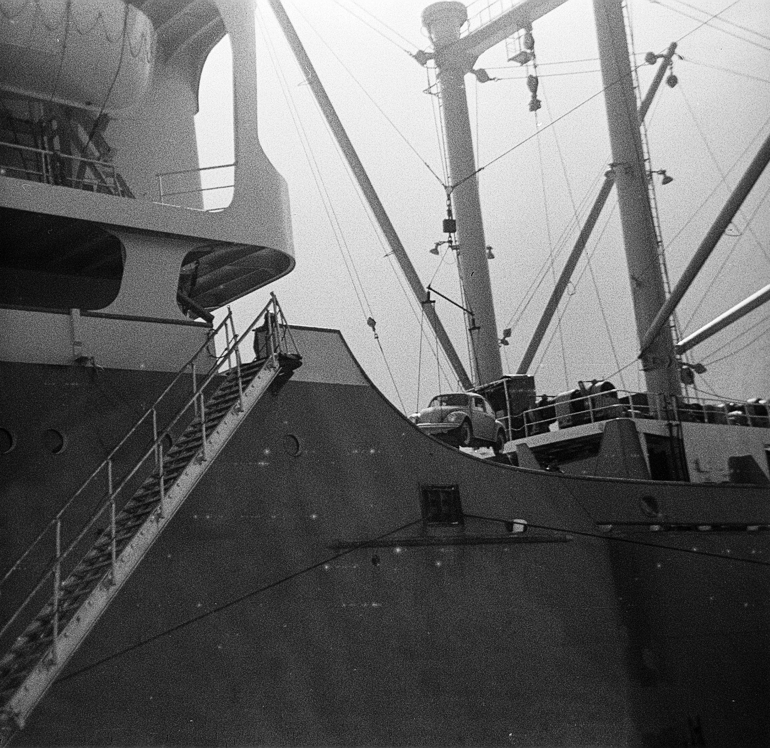 Foto von einem in Emden bei VW hergestellten VW-Käfer, der auf das Schiff JOHANN SCHULTE verladen wird, und in die USA gebracht werden soll. Links am Schiff eine Gangway. 1967. Foto: Erwin Thomasius.