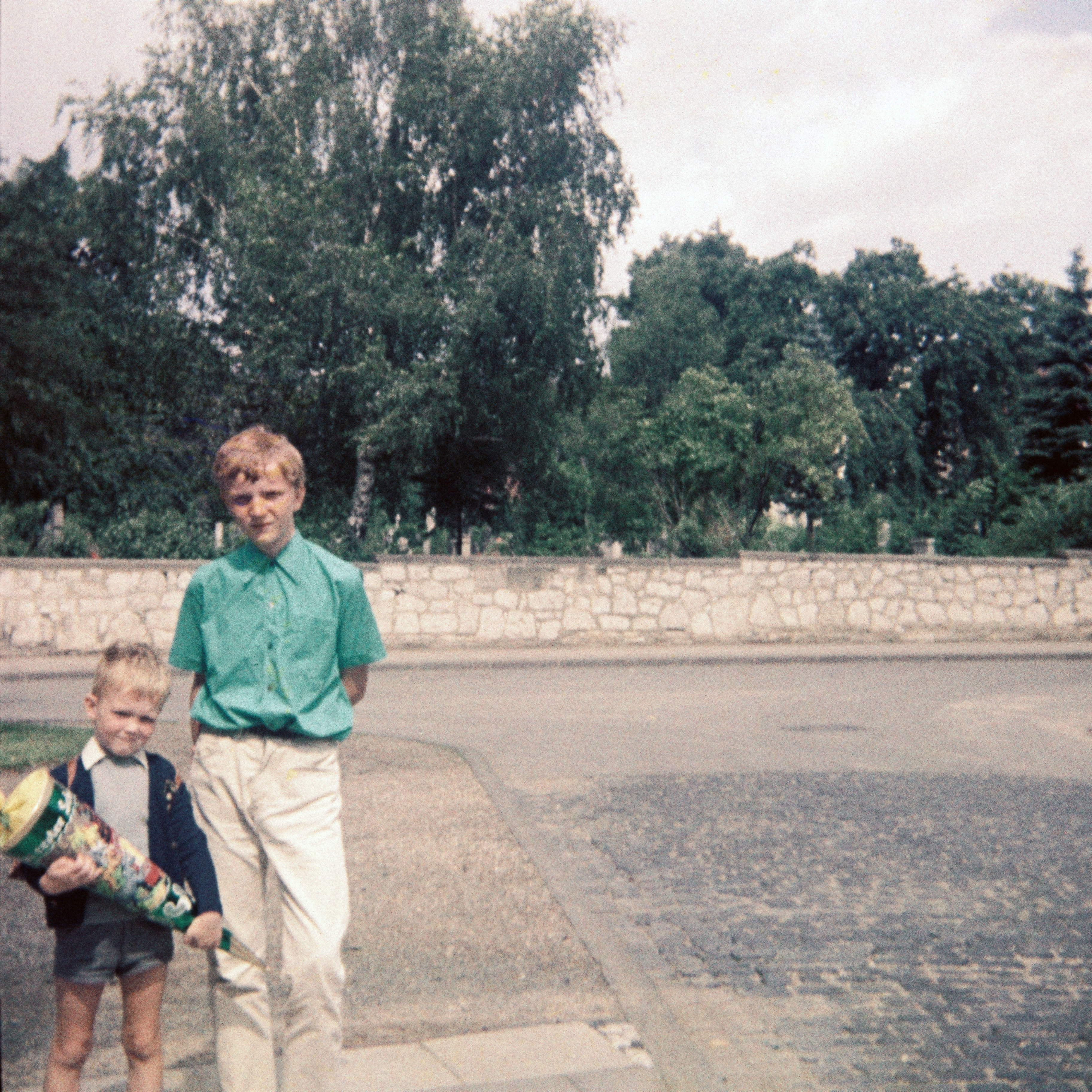 Ein Junge am Tage seiner Einschulung mit seinem Schultornister aus Leder auf dem Rücken und seiner Zuckertüte in den Händen in der Sprengerstraße/ Ecke Struckmannstraße in Hildesheim im Jahre 1967.