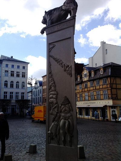 Farbfoto: Das Kunstwerk Die Bardowicker Gesäßhuldigung des Künstlers Peter Lenk auf dem Alststädter Markt in Schwerin im April des Jahres 2015. Fotograf: R.I.