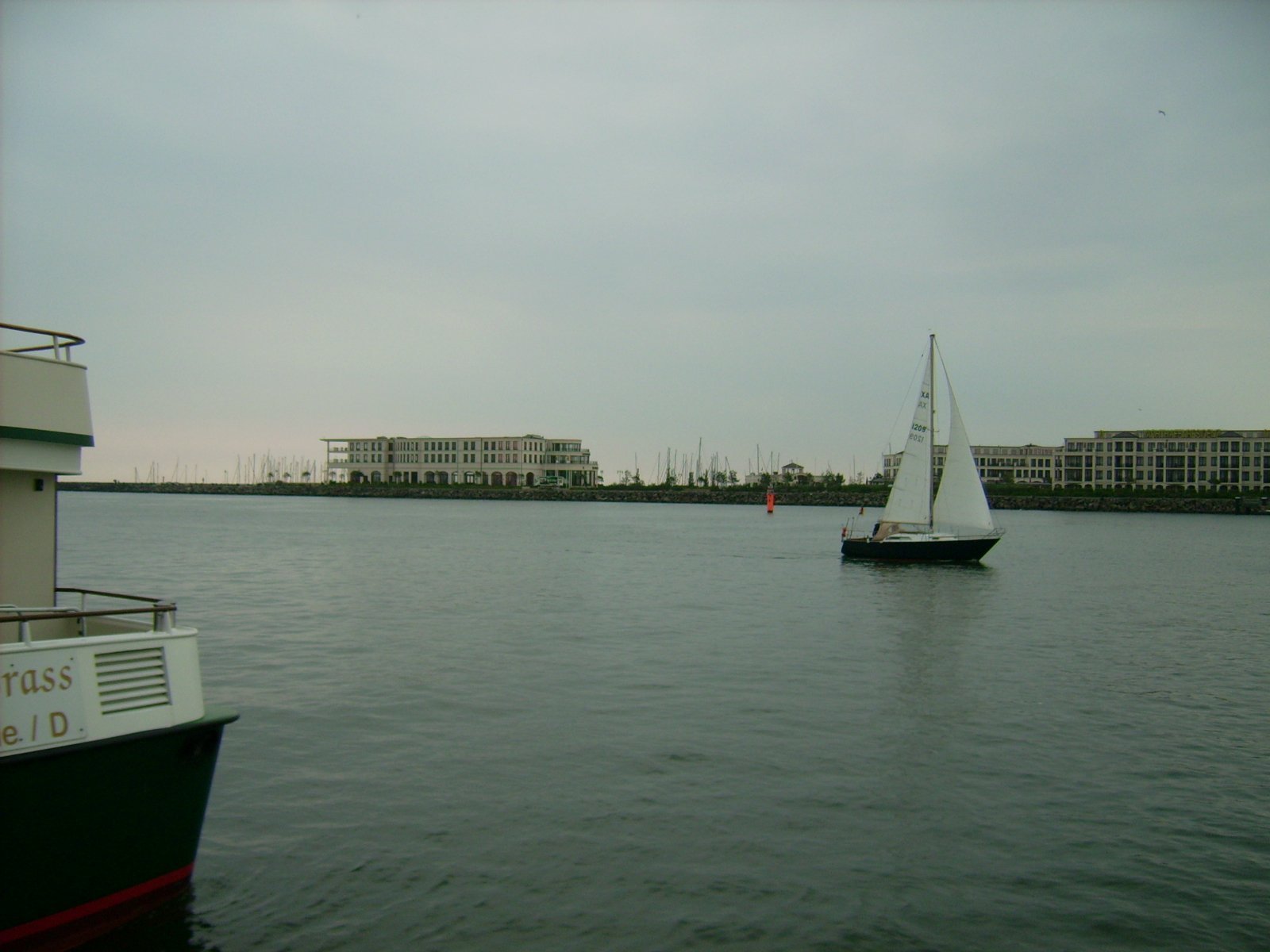 Farbphoto: Ein Segelboot und das Hafenrundfahrtsschiff "Käpp'n Brass" in Warnemünde im Juni 2009. Photograph: Bernd Paepcke.